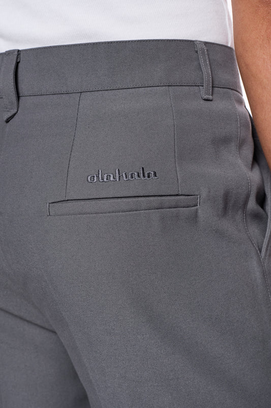 CC Dress Pants Slim Fit Grau mit asymmetrischer Tasche, gesticktem OLAKALA-Logo und versetzter Seitennaht, aus weichem, robustem Köper-Gewebe.