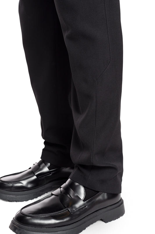 Nahaufnahme von CC Dress Pants Slim Fit Black mit asymmetrischer Tasche, Paspeltaschen hinten, Bundfalten und gesticktem OLAKALA Logo über der rechten Gesäßtasche.