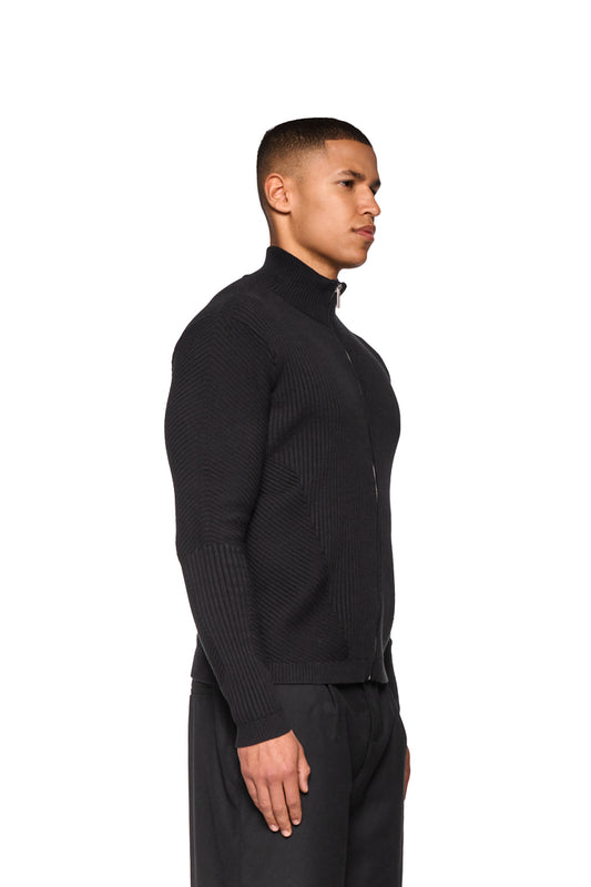 Mann trägt CI Slim Knit Jacket Black, schmal geschnitten mit Reißverschluss und Strickmuster, präsentiert im OLAKALA Onlineshop.