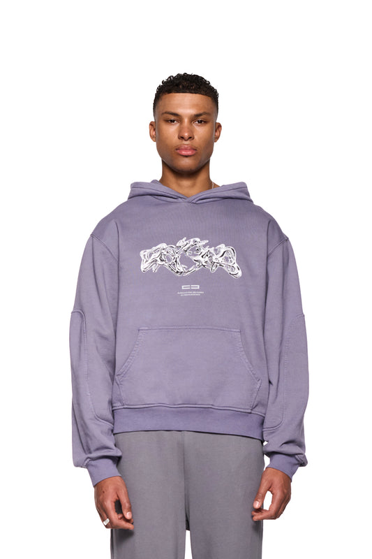 Mann trägt Greyzone Hoodie Lilac mit Kängurutasche, Teilungsnähten an Ärmeln und Rücken, sowie Siebdruck-Grafik auf der Vorderseite.