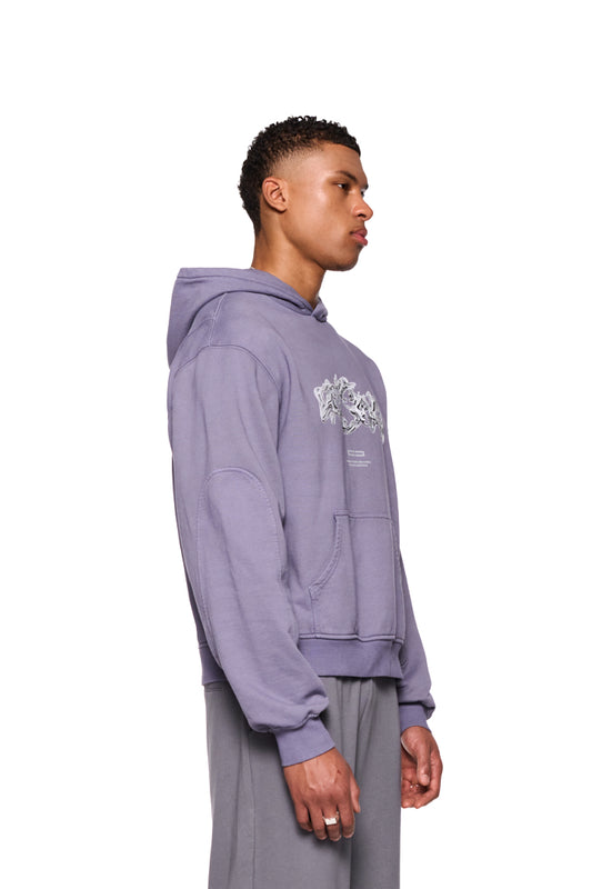 Mann im Greyzone Hoodie Lilac mit Kängurutasche und Ripp-Bündchen, zeigt Teilungsnähte und Siebdruckgrafik auf der Vorderseite.