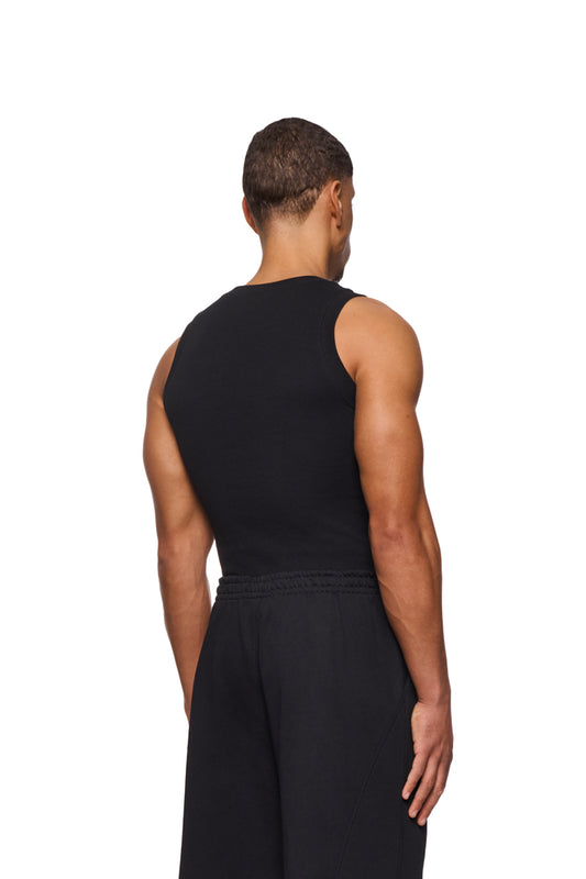 Mann trägt CC Core Tanktop Black aus elastischem Ripp-Stoff mit gesticktem OLAKALA Icon auf der Brust, enge Passform, unisex.