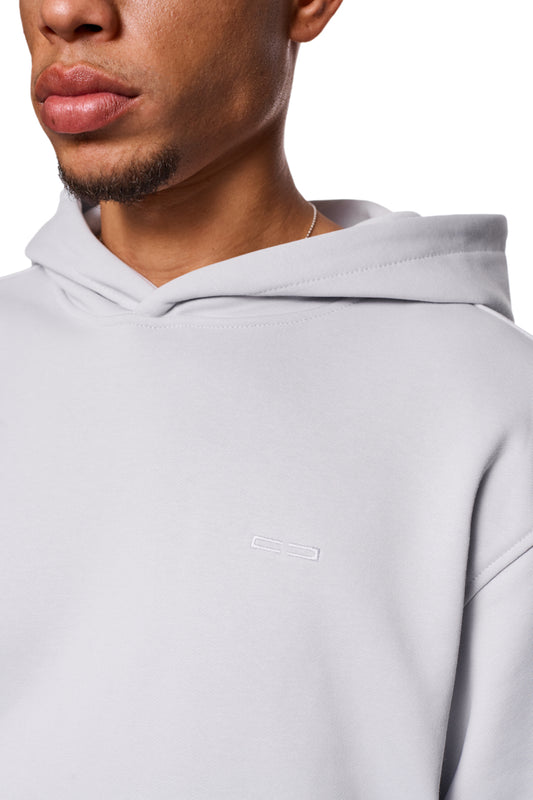 Nahaufnahme des CC Core Hoodie Gray mit strapazierfähiger Mischfaser, Rippbündchen, Kängurutasche und regulärer Passform. Perfekt für Komfort und Langlebigkeit.