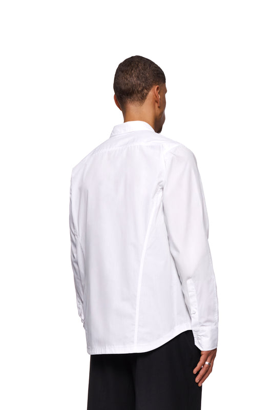Mann trägt CC Core Button Shirt White mit verdeckter Knopfleiste und verstärktem Kragen. Reguläre Passform, unisex, langlebige Mischfaser, erhöhte Tragekomfort.
