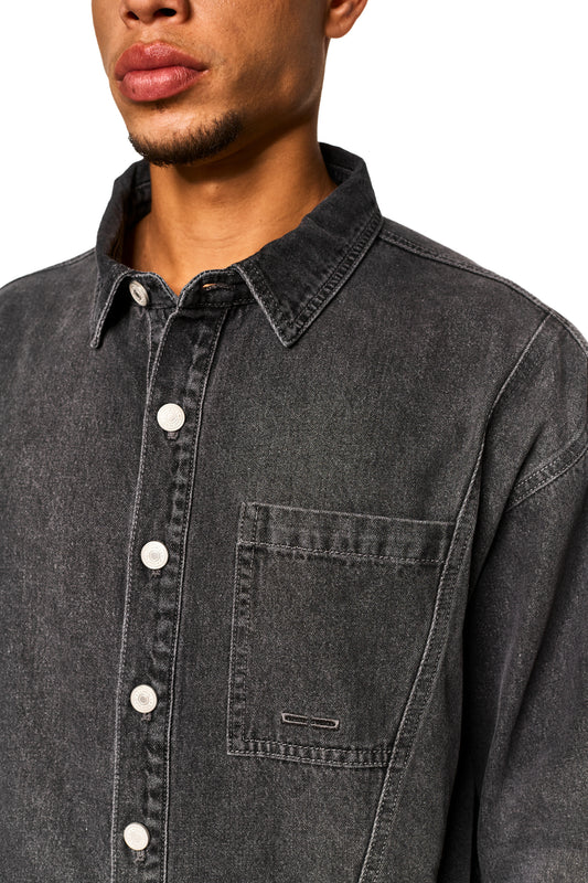 0asis Denim Overshirt Black, Nahaufnahme von Gesicht und Knopfleiste, zeigt weichen Denim, mittige Knopfleiste, Brusttaschen mit Logo-Stickerei, Teilungsnähte und geprägtes OLAKALA-Patch.