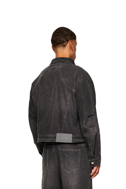 Nahaufnahme des 0asis Denim Overshirt Black mit geprägtem OLAKALA Patch, Knopfleiste, aufgesetzten Brusttaschen und zweiteiligen Ärmeln mit Falten im Ellenbogenbereich.