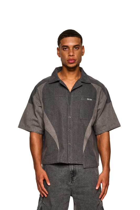 Nahaufnahme eines Mannes mit Echoes Denim Icon Shirt Gray, das einen stilvollen Kragen und eine Brusttasche zeigt, ideal für den modernen Look von OLAKALA.