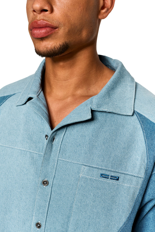 Nahaufnahme des Echoes Denim Icon Shirt Blue mit kubanischem Kragen, Brusttasche und Logo-Stickerei. Lockerer Schnitt aus leichtem, robustem Köper-Gewebe.