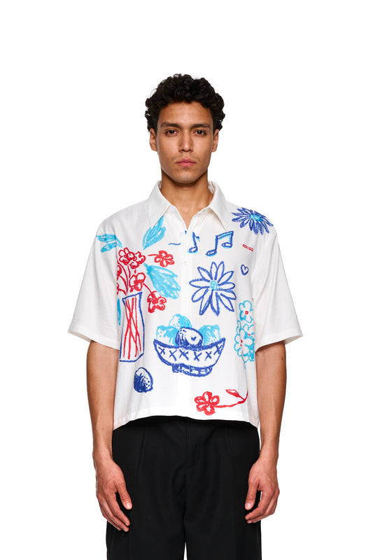 Mann im weißen Crayon Summer Shirt Graphic mit Zeichnungen, nah am Gesicht und Korbskizze. Produkt von Offizieller OLAKALA® Onlineshop.