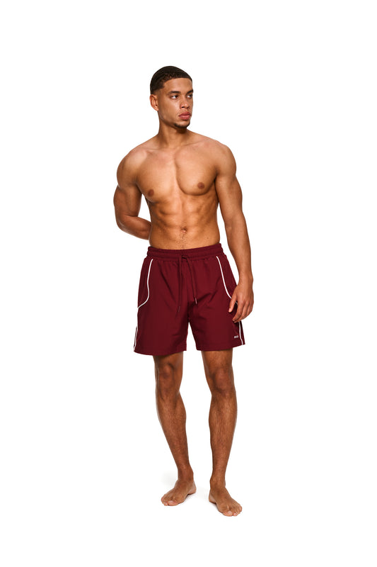 Nahaufnahme eines Mannes in den 0asis Swim Shorts Red mit elastischem Material, Mesh-Innenfutter und Seitentaschen, ideal für maximale Bewegungsfreiheit am Pool oder Strand.