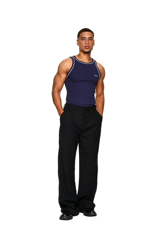 Nahaufnahme eines Mannes im Tanktop mit gesticktem OLAKALA-Icon und kontrastierenden Paspeln, präsentiert als Contrast Tanktop Navy Blue im offiziellen OLAKALA® Onlineshop.