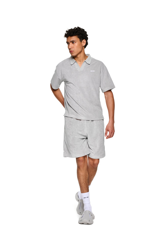 Mann trägt Terry Polo Gray aus weichem Frottee, mit Logo-Stickerei auf der Brust, präsentiert im OLAKALA® Onlineshop.