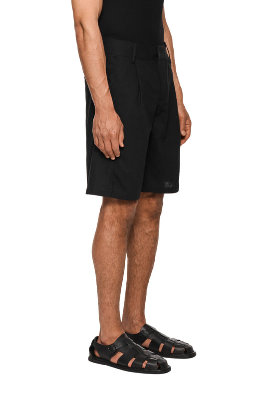 Schwarze Leinen-Shorts mit Bundfalten, französischen Taschen und versetzter Seitennaht. Unisex-Design mit natürlicher Haptik und Pflegeleichtigkeit.