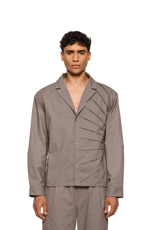 Sun Linen blazer with asymmetric safari collar, removable shoulder padding and shirt button placket, shows sun detail and pleats; unisex, regular fit.