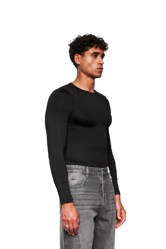 Model trägt das CC Core Slim Fit Longsleeve Black, ein bequemes, formstabiles Oberteil aus weichem Stretchmaterial, ideal kombinierbar und perfekt für jeden Anlass.