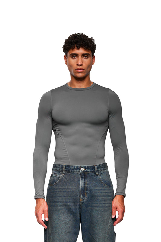Junger Mann trägt CC Core Slim Fit Longsleeve Gray, ein eng anliegendes, bequemes Shirt aus Stretch-Material, ideal für vielseitige Kombinationen, von OLAKALA.