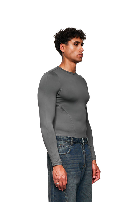 Junger Mann in CC Core Slim Fit Longsleeve Gray, das komfortabel und dehnbar ist, kombiniert mit blauen Jeans.