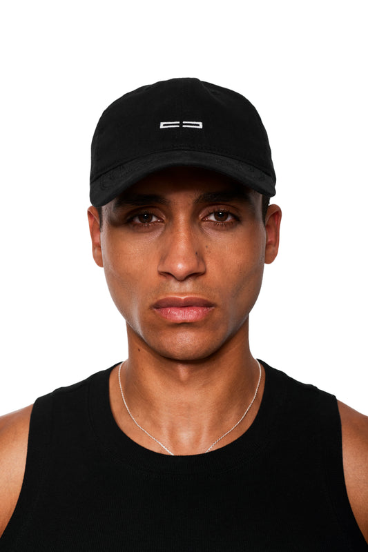 Nahaufnahme eines jungen Mannes mit schwarzem CC Icon Cap Black mit gesticktem OLAKALA Logo, verstellbar durch Metallclip hinten, kombiniert mit schwarzem ärmellosen Shirt.