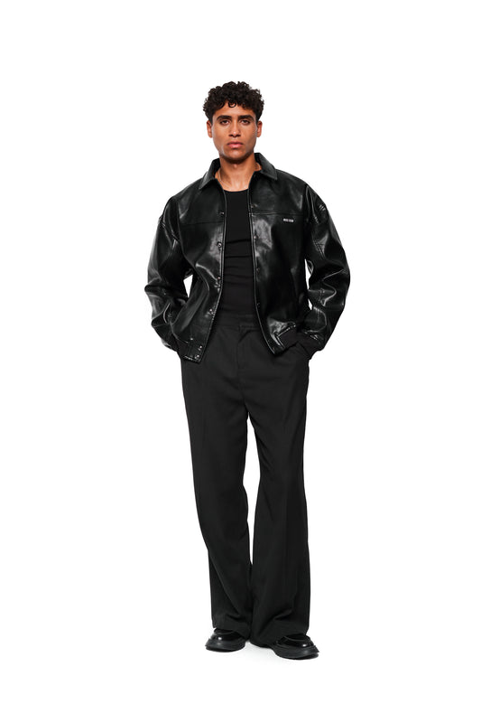 Männliches Model trägt die CC Leather Jacket Icon Black aus veganem Lederimitat von OLAKALA, mit gesticktem Icon, Leistentaschen und Reißverschlussinnentasche.