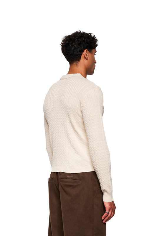 Men's model wearing Exquisite Cable Knit Polo Cream, showing cable knit pattern and unisex close fit, with polo collar and knitted cuffs, visible from behind.