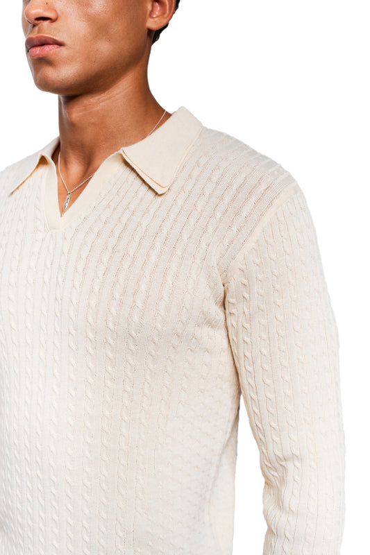 Person wears the Exquisite Cable Knit Polo Cream: cream-colored, close-fitting cable knit sweater with a polo-style collar and fine side knit details, complemented by a silver necklace.