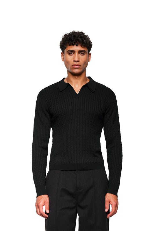 Junger Mann trägt Exquisite Cable Knit Polo Black mit V-Ausschnitt, schmalem Polo-Kragen, Zopf-Strickmuster und enganliegender Passform.