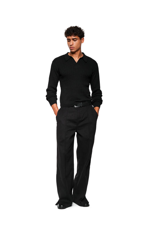 Male model wears Exquisite Cable Knit Polo Black with polo collar, cable knit pattern, close fit, combined with tailored pants and leather shoes.