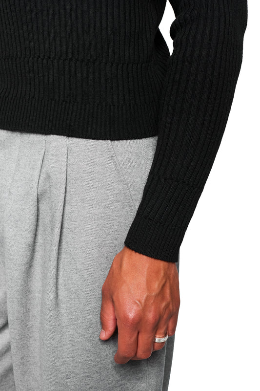 Exquisite Knit Longsleeve Black with a tight cut, knitted waistband and various knitted patterns, worn with gray pleated pants.