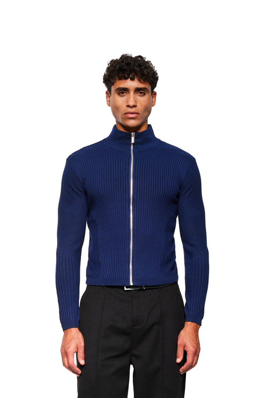 Junger Mann trägt die Exquisite Knit Jacket Navy Blue mit körperbetonendem Strickmuster, Stehkragen und eng anliegender Passform, kombiniert mit schwarzen, maßgeschneiderten Hosen.