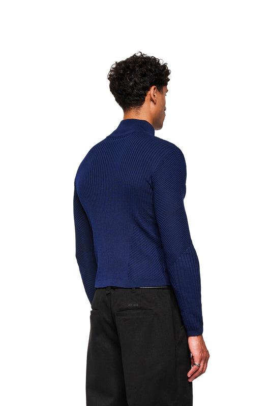 Back view of the model in the Exquisite Knit Jacket Navy Blue with stand-up collar and body-hugging knit, combined with black pants.