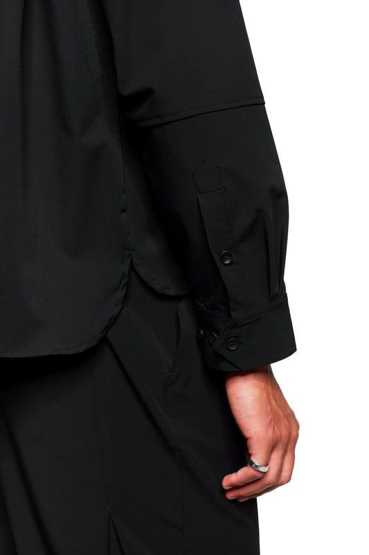 Close-up of the Exquisite Tech Shirt Black with double collar, chest pocket with OLAKALA embroidery, rounded hem and stretchy material. Unisex, loose fit.