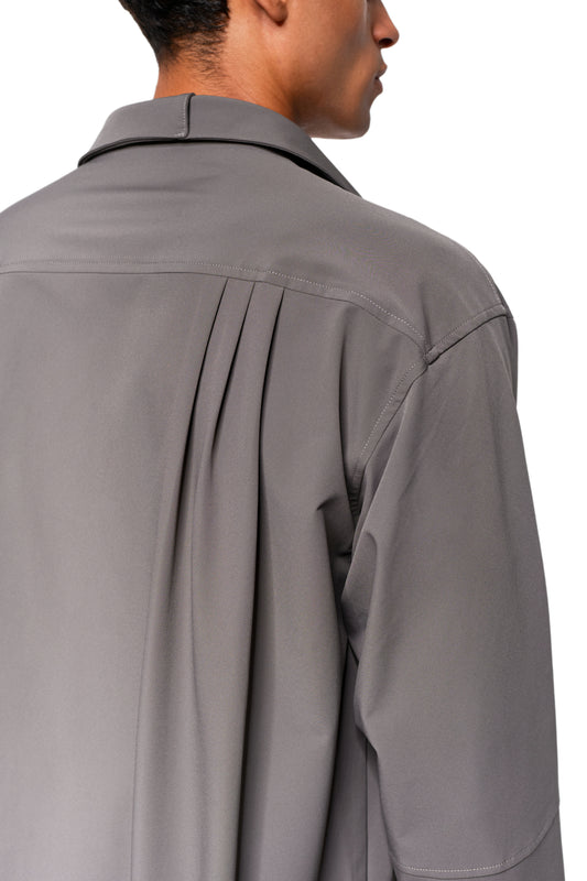 Close-up of the Exquisite Tech Shirt Gray with loose cut, straight back yoke, narrow box pleats and small collar, worn by one person.