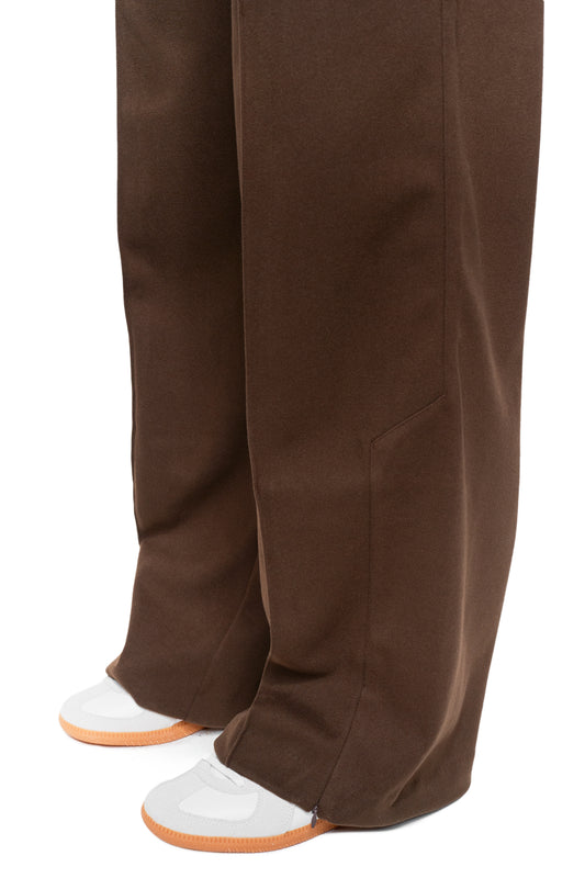 Unisex Exquisite Dress Pants Brown, loosely cut, with pleats and offset side seams, worn with white sneakers, represent OLAKALA's stylish, functional fashion.