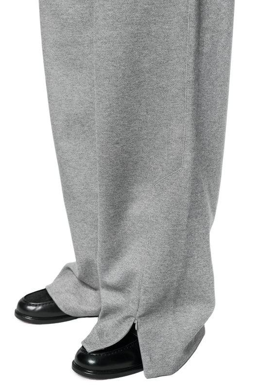 Close-up of Exquisite Dress Pants Gray with wide leg, zipper detail at hem and embroidered OLAKALA icon, worn over shiny black leather shoes.