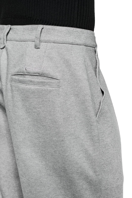 Person wears Exquisite Dress Pants Gray with pleats, offset side seam and embroidered OLAKALA icon. On display: Waistband with loops, back pocket, side zipper.