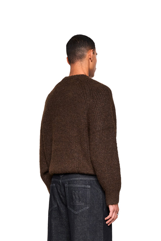 Mann von hinten in dunklen Jeans, trägt den Fuzzy Knit Sweater Brown mit cropped, boxy Silhouette und weicher Struktur.