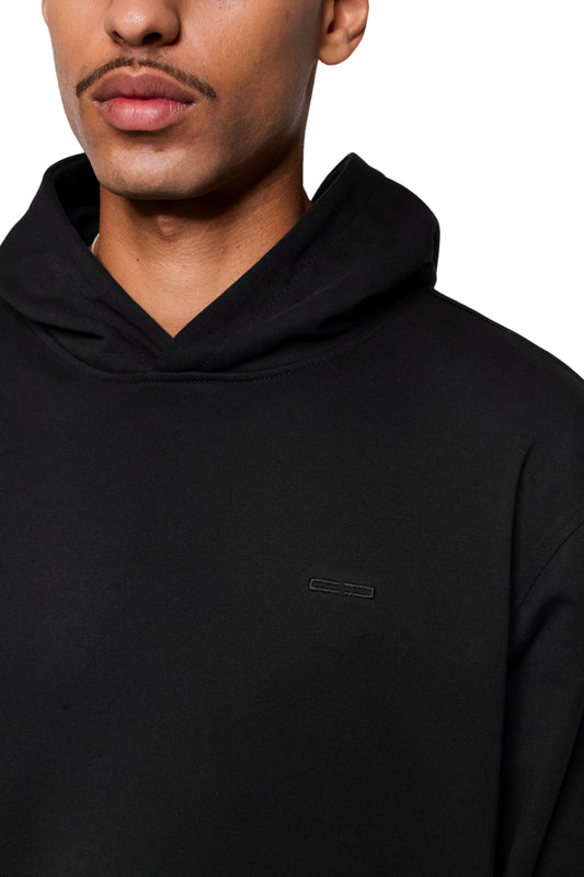 Person trägt Mokka Hoodie mit kleinem Logo auf der Brust; nahtfreier Komfort dank spezieller Ärmel- und Seitennähte, inspiriert vom CC Core Hoodie-Design.