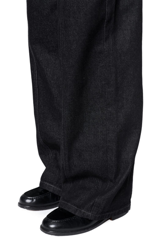 Loose-Fit Raw Denim Pants mit weitem Bein über schwarzen Loafers, markante Nahtdetails und French-Pockets, aus unbehandeltem Denim für individuellen Charakter.