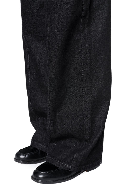 Loose-Fit Raw Denim Pants mit weitem Bein über schwarzen Loafers, markante Nahtdetails und French-Pockets, aus unbehandeltem Denim für individuellen Charakter.