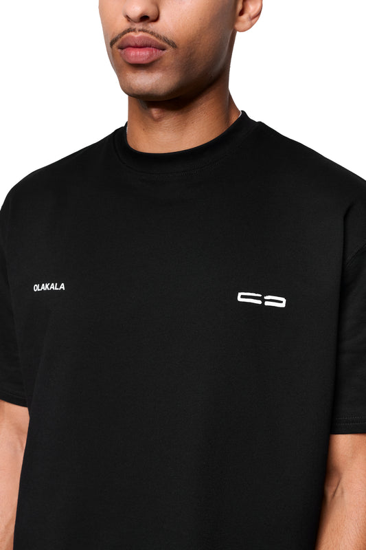 Mokka T-Shirt Black mit OLAKALA und stilisiertem C3-Print auf der Brust, präsentiert in einem studioähnlichen Bildausschnitt.