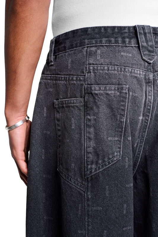 Nahaufnahme der Void Denim Pants von hinten, zeigt große Gesäßtaschen und eine leichte Taperung am Saum. Sichtbar: versetzte Seitennaht, asymmetrische Taschen.