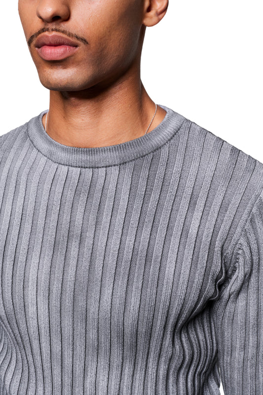 Person trägt einen Void Knit Longsleeve mit geripptem Muster und Rundhals, kombiniert mit einer dünnen Silberkette, ideal als Blickfang oder Layering-Piece.