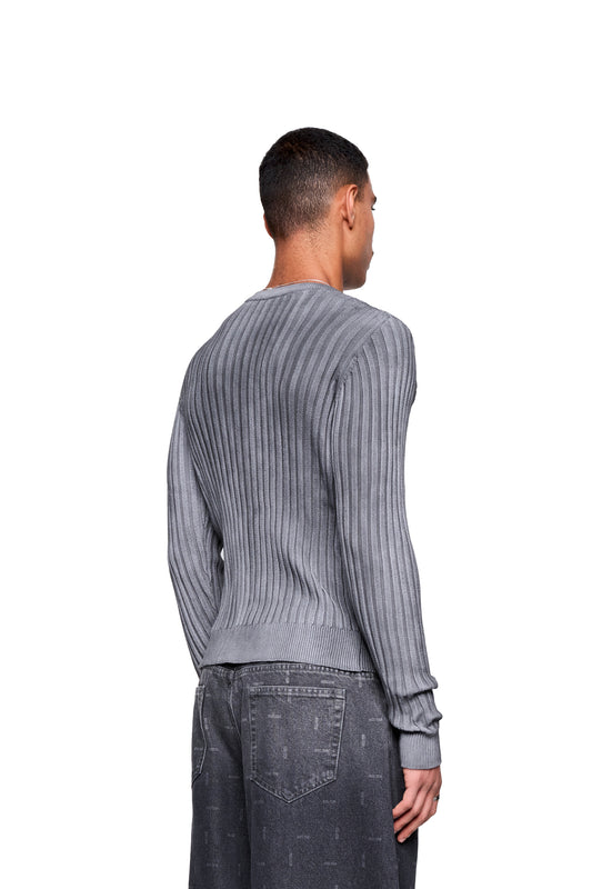 Rückansicht eines Mannes im Void Knit Longsleeve, strukturiertes Design mit progressivem Finish, geeignet als zentrales Outfit-Element oder markanter Layering-Akzent.