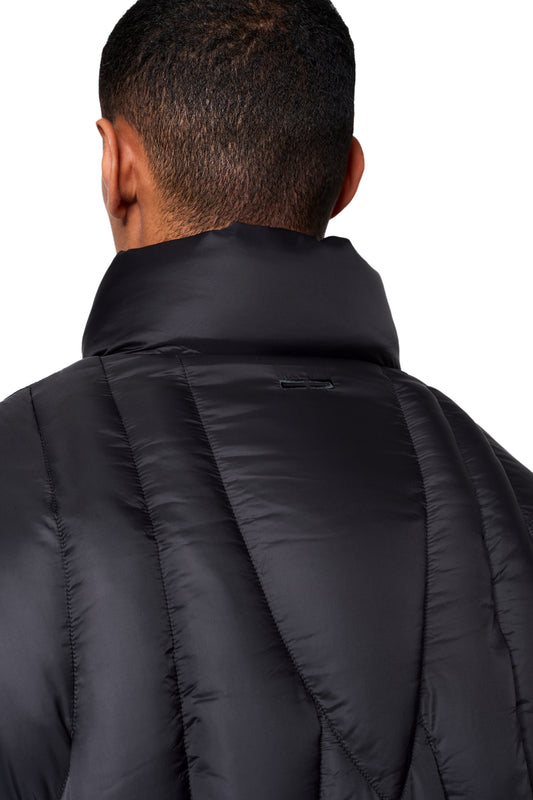 Person von hinten in einer schwarzen Void Puffer Jacket mit Stehkragen und gesteppten Linien, zeigt das OLAKALA-Logo dezent am Kragen.