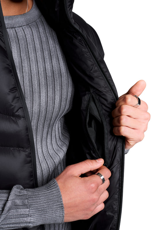 A person is wearing a Void Puffer Vest, showing an inner zippered pocket. The vest has a voluminous, sleeveless silhouette, ideal for layering.