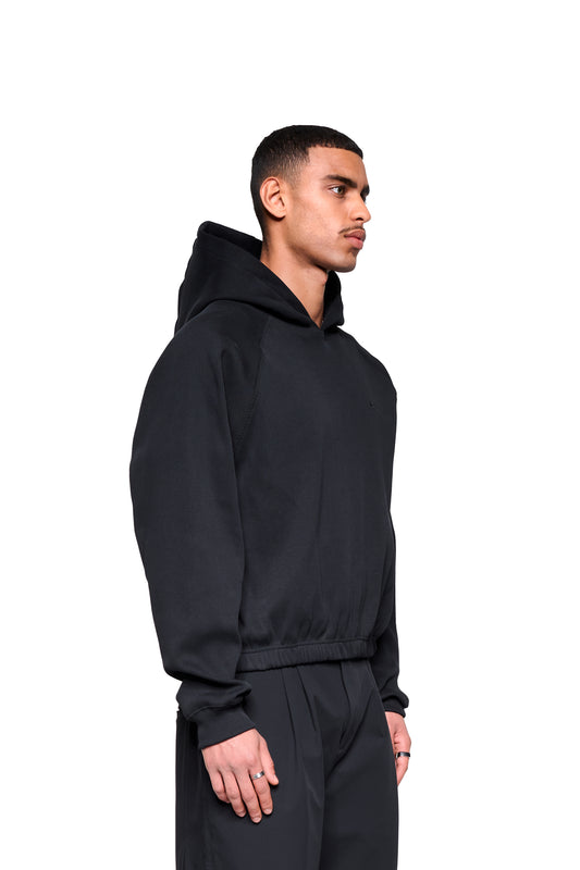 Junger Mann im Void Rib Hoodie mit markanter Rippstruktur und lockerer Silhouette, präsentiert minimalistischen, modernen Look vor weißem Hintergrund.