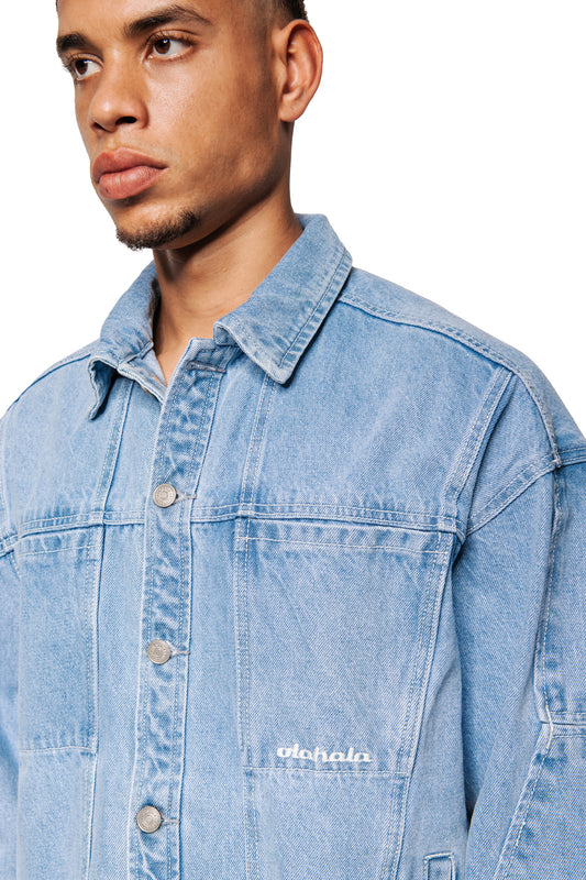Young man wears CC Blue Denim Jacket with press studs and embroidered OLAKALA logo on the breast pocket, classic collar and distinctive seam details.