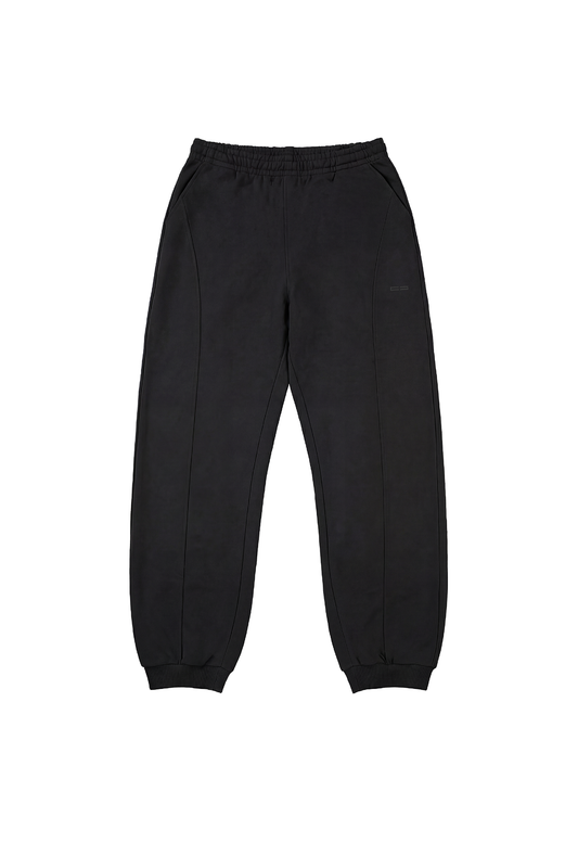 CC Core Sweatpants in Schwarz mit elastischem Bund, Seitentaschen, Teilungsnähten und Rippbündchen, flach auf weißem Hintergrund präsentiert.
