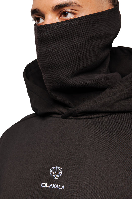 Person wearing Discreet Mask Hoodie Black with raised collar. The eyes, embroidered OLAKALA logo and 