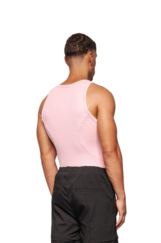 Back view: Model wears the E.O.I Cotton Candy tank top in ribbed knit, with dividing seams and embroidered OLAKALA logo, combined with dark shorts.